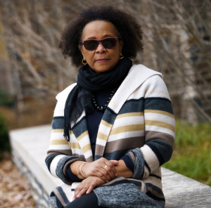 Photo of Michaeline Crichlow seated on stone bench on Duke campus