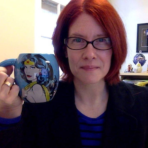 Photo of Jules Odendahl-James, holding Wonder Woman mug